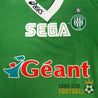 Vue rapprochée des sponsors SEGA et Géant sur le maillot vert de l’AS Saint-Étienne