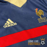 Zoom sur la poitrine du maillot France 98 avec logos Adidas et FFF brodés et bande rouge centrale