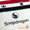 Détail logo Snapdragon sur le torse du maillot Manchester United 2024-2025, couleurs noir, blanc et rouge
