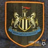 Écusson brodé de Newcastle United sur le maillot extérieur vintage Adidas, années 1990, avec les deux hippocampes emblématiques.