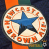 Zoom sur le sponsor Newcastle Brown Ale imprimé sur le côté droit du maillot extérieur vintage Adidas de Newcastle United.