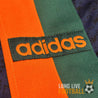 Détail du logo Adidas brodé en orange sur la bande verte verticale du maillot extérieur vintage de Newcastle United